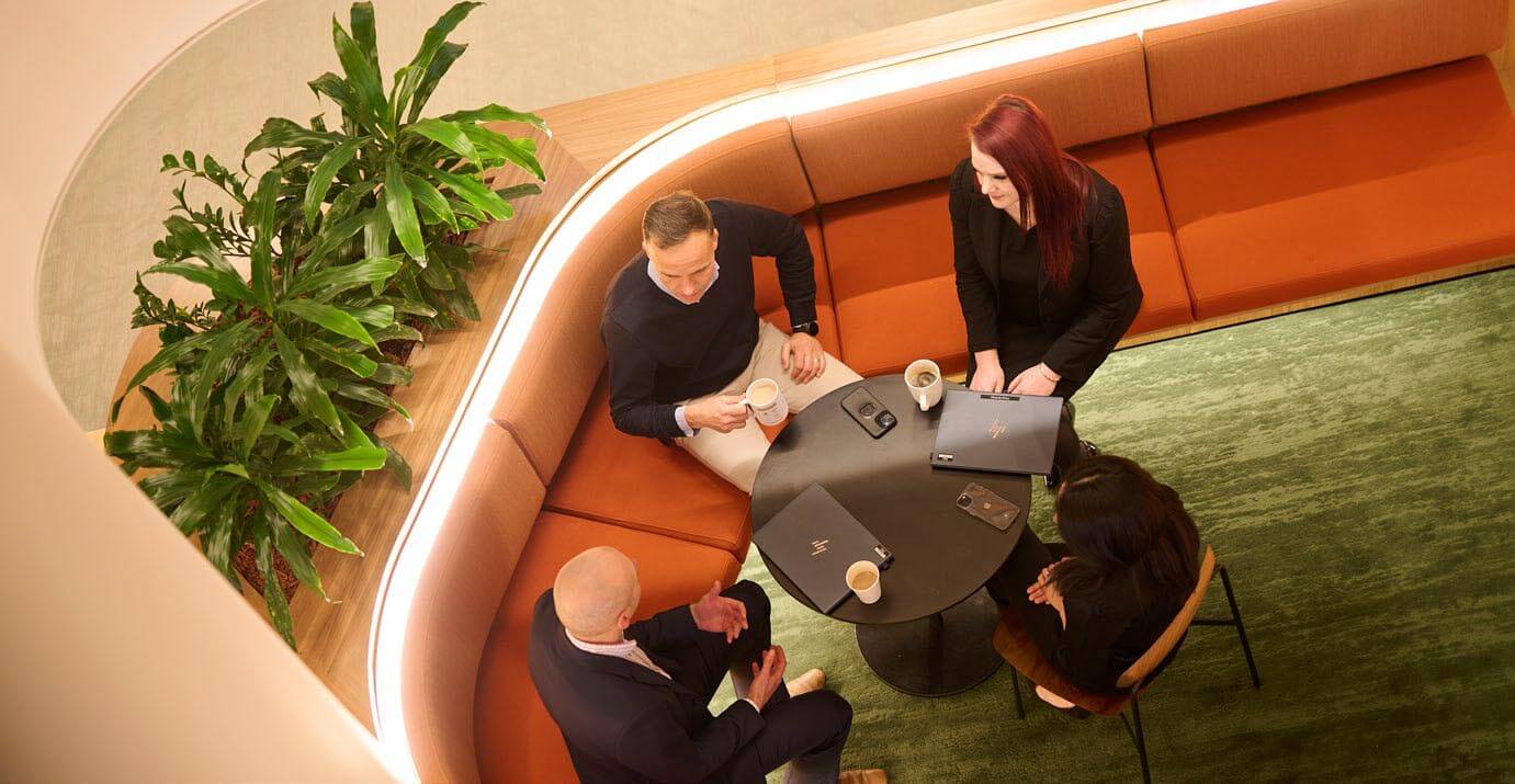 Looking down on four people sitting around a table having a discussion 