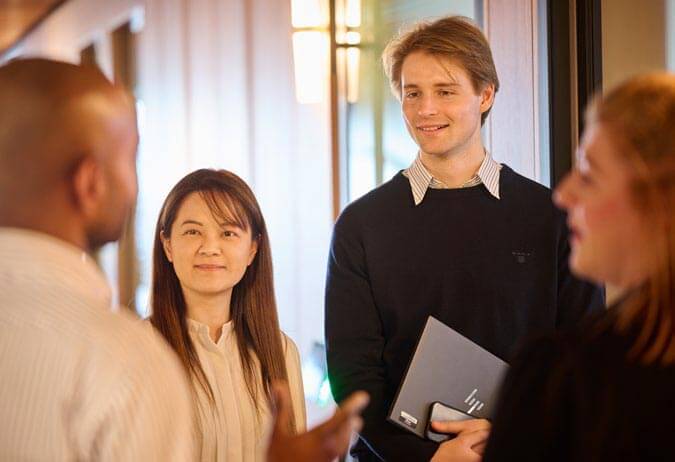Four people in an office talking. 