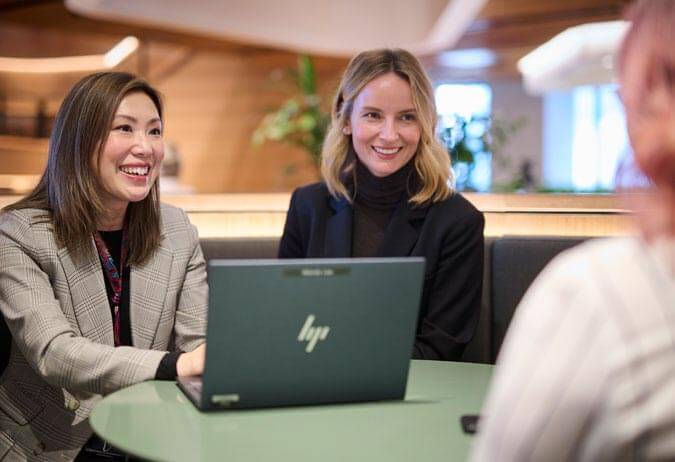 Three people having a meeting around a computer in an office.